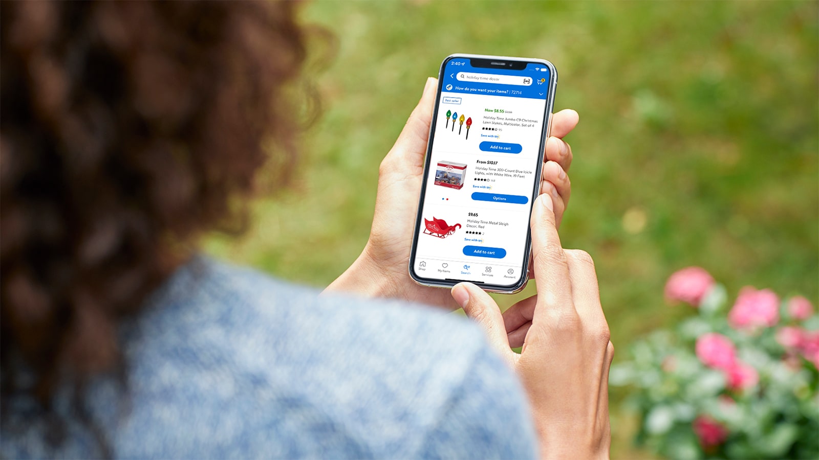 A woman holds a phone with Walmart.com open on the screen