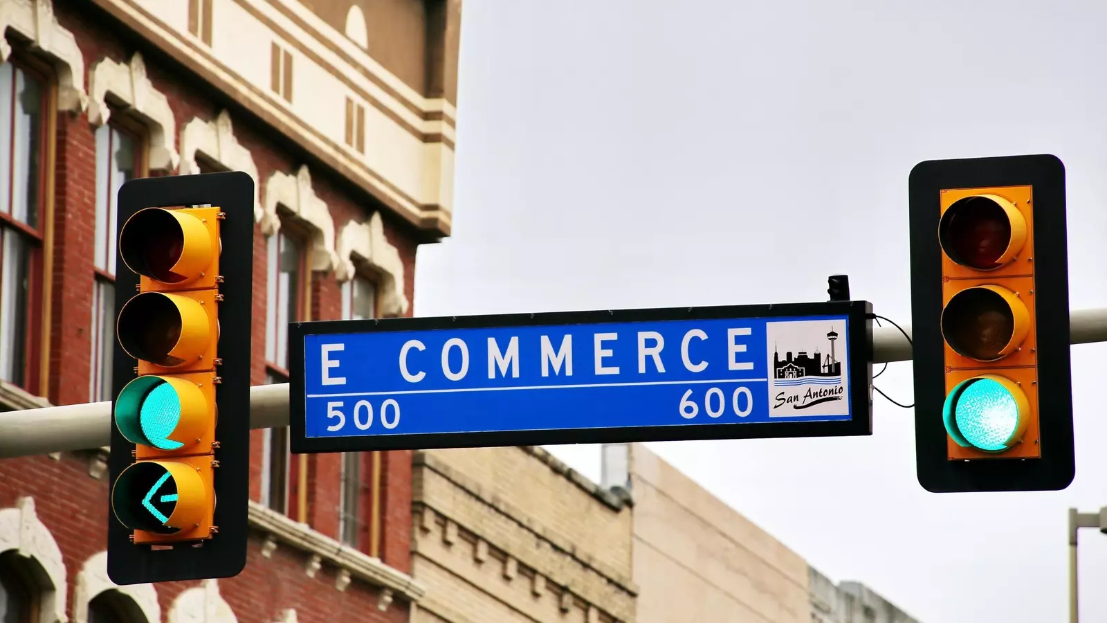 A shot of a road sign amongst traffic lights, instead of a street name the sign reads "ecommerce"