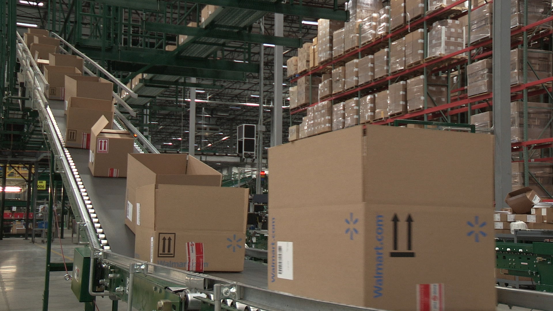 A picture of a Walmart fulfillment center, open Walmart.com boxes are coming down a packing line